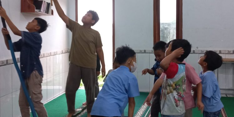 Santri Madrasah Diniyah Takmiliyah (MDT) Al Ubaidah berpartisipasi dalam kegiatan kerja bakti membersihkan lingkungan sekitar masjid. Foto: LINES.