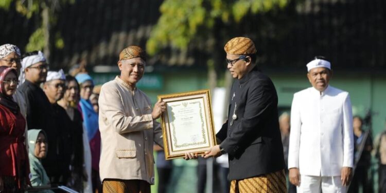 Agus Purwanto, warga LDII Karawang yang mengajar di SMA Budi Mulia, Karawang, Jawa Barat menerima penghargaan saat Hardiknas. Foto: LINES.