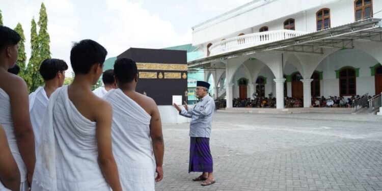 Santri dan calon jamaah haji tahun 2025, mengikuti simulasi manasik haji di Ponpes Millenium Alfiena, Nganjuk, Jawa Timur yang dibimbing oleh Habib Ubaidillah Alhasny. Foto: LINES.