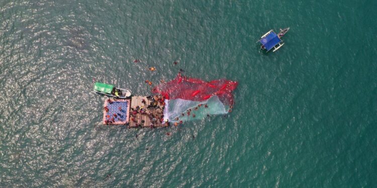 Menyemarakkan hari kemerdekaan Republik Indonesia, ratusan relawan gabungan Forum Potensi SAR (Fotsar) dan Asosiasi Keselamatan Selam Indonesia (AKSI) membentangkan bendera merah putih raksasa di perairan Merak, Minggu (17/8). Foto: LINES