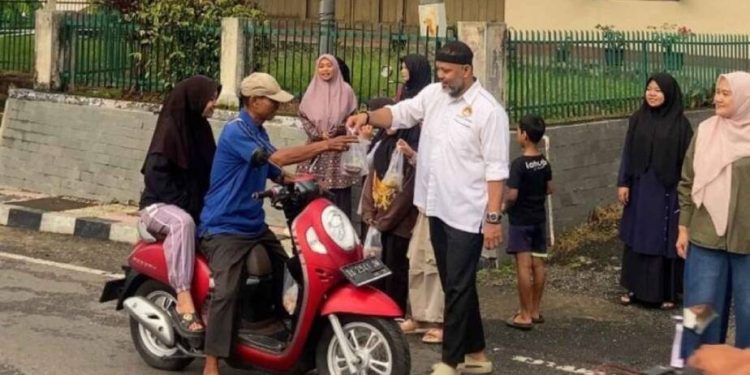 Ketua DPD LDII Kota Sawahlunto H. Dedy Salman membagikan takjil kepada pengendara motor. Foto: LINES.