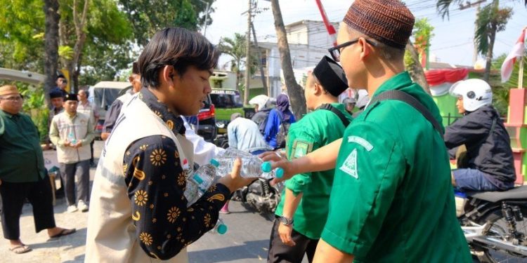 Relawan LDII membagikan air mineral kepada peserta Muktamar ke-35 NU. Foto: LINES.