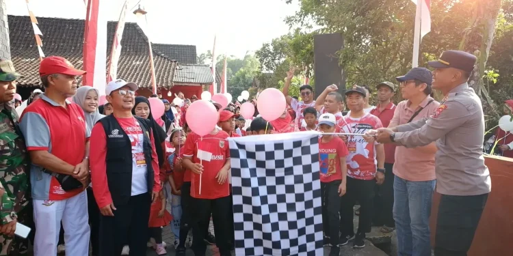 Wakil Kapolsek Tingkir, Harjono mengibarkan bendera start sebagai tanda dimulainya Jalan Sehat dalam rangka memperingati Hari Ulang Tahun (HUT) ke-81 Kemerdekaan Republik Indonesia yang digelar Pimpinan Cabang (PC) LDII Tingkir. Foto: LINES