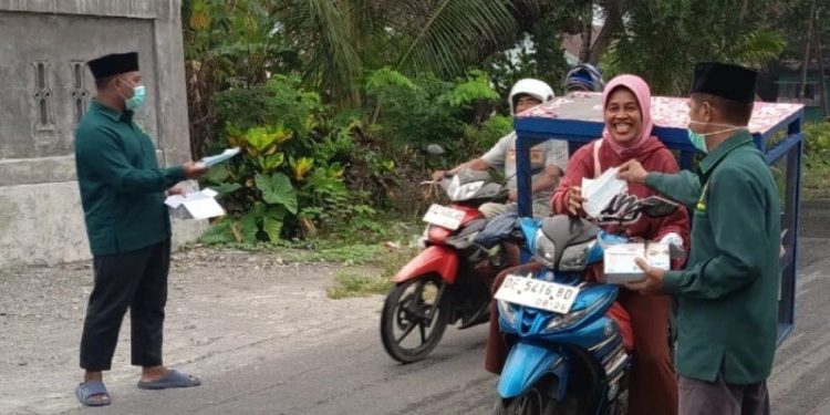 LDII Maluku Tengah membagikan masker kepada warga sekitar. Wilayah tersebut juga terdampak asap kebakaran hutan dan lahan, yang mengganggu pernapasan. Foto: LINES.
